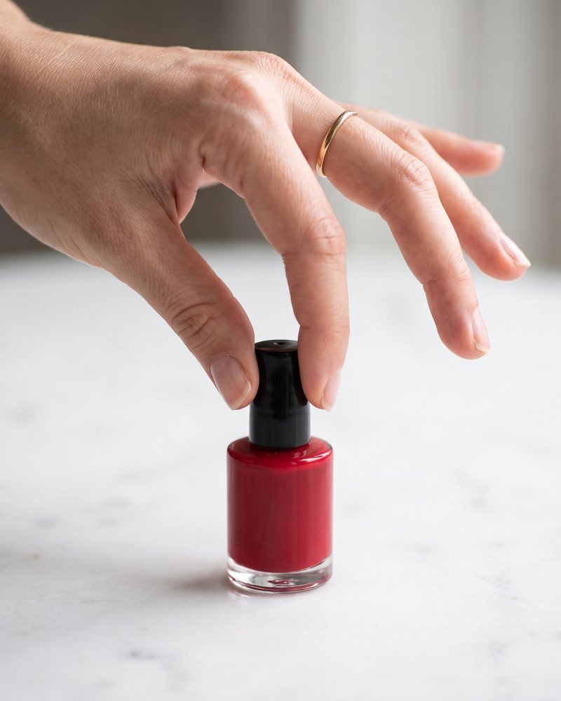 Fingers pinching a tiny polish cap
