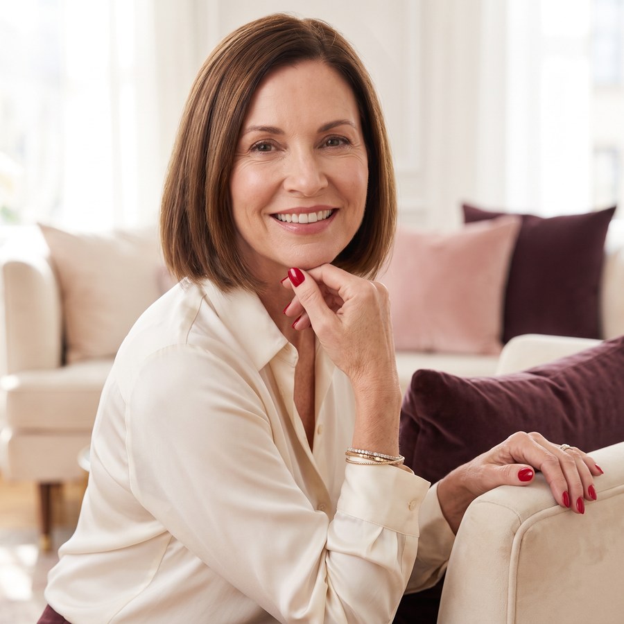 A woman smiling, showing her cherry nails